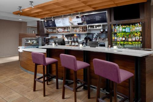 a bar with purple bar stools in a restaurant at Courtyard Detroit Brighton in Brighton