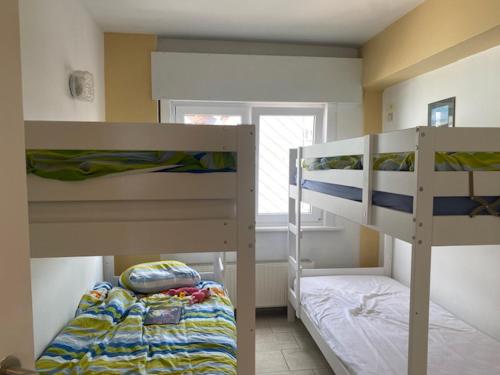 um quarto com 2 beliches e uma janela em Appartement vue sur mer - Splendide localisation! em Koksijde