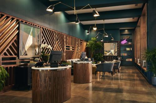 a lobby with tables and chairs and plants at Kinley Chattanooga Southside, a Tribute Portfolio Hotel in Chattanooga