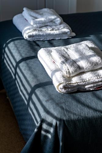 a pile of towels sitting on top of a bed at Greyfriars in Clacton-on-Sea