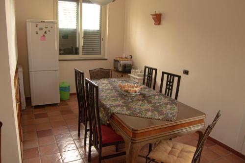 a dining room with a table and chairs and a refrigerator at A Nespulara in Galati Marina