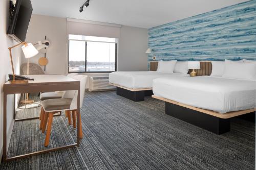 a hotel room with two beds and a desk at TownePlace Suites by Marriott Sidney in Sidney