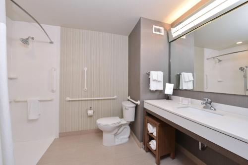 y baño con aseo, lavabo y espejo. en Courtyard by Marriott St. Louis St. Peters en Saint Peters