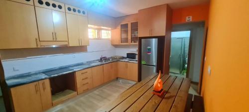 皮拉雅的住宿－Helton´s Residence，厨房配有木桌和冰箱。