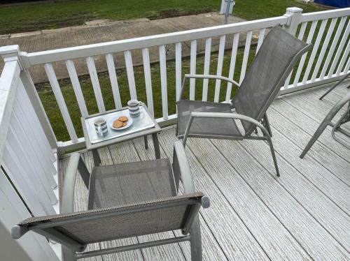 a chair and a plate of food on a deck at Chalet 40, Cleethorpes in Humberston