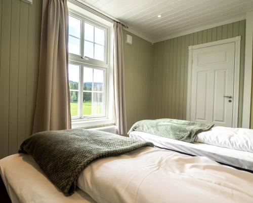 a bedroom with two beds and a window at Villa Fregn in Ljørdal