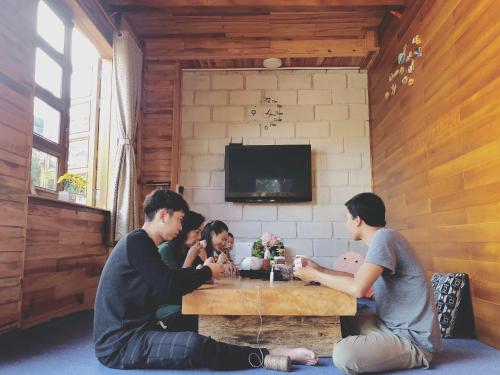 eine Gruppe von Menschen, die in einem Raum an einem Tisch sitzen in der Unterkunft Simplewoods Homestay in Da Lat in Da Lat