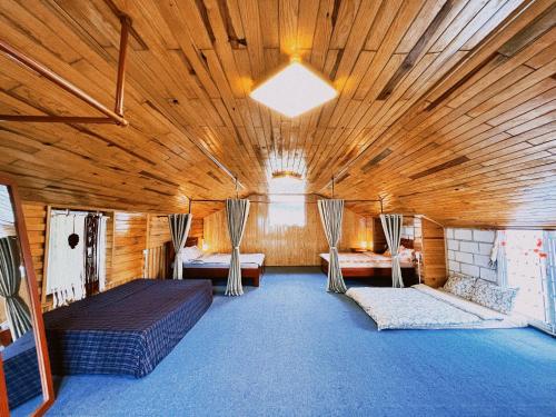 a large room with two beds and chairs in it at Simplewoods Homestay in Da Lat in Da Lat