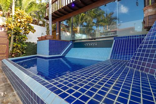 a swimming pool with blue tiles on a house at Hotel Natural - SPA & Lazer in Brotas