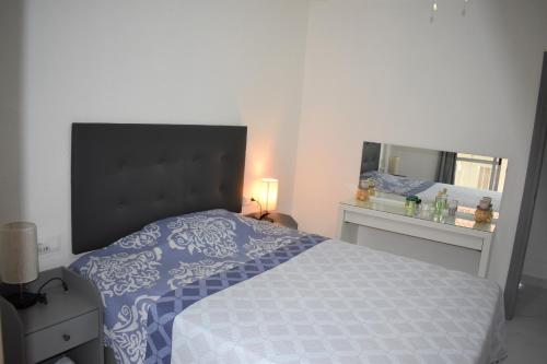 a bedroom with a bed and a mirror at Torri apartments - 3 mins walk to beach in Torrevieja