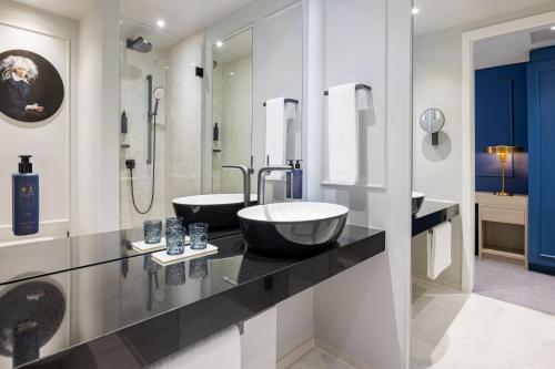 a bathroom with two sinks and a shower at Hotel Luc, Autograph Collection in Berlin