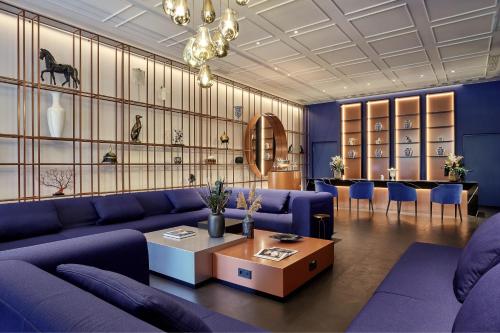 a living room with purple couches and a table at Hotel Luc, Autograph Collection in Berlin
