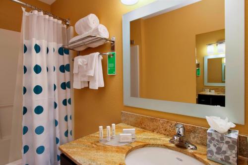 TownePlace Suites San Jose Cupertino في سان خوسيه: حمام مع حوض ومرآة