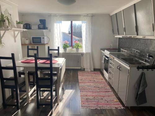 cocina con mesa y sillas y cocina con fregadero en Persgård lägenhet övervåning en Kungsbacka