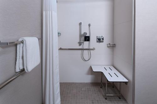 baño blanco con ducha y lavamanos en Courtyard by Marriott Dallas Richardson at Spring Valley, en Richardson