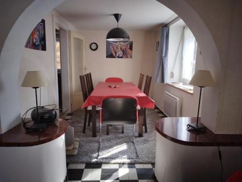 uma sala de jantar com uma mesa vermelha e cadeiras em Le Lohrnest em Lohr