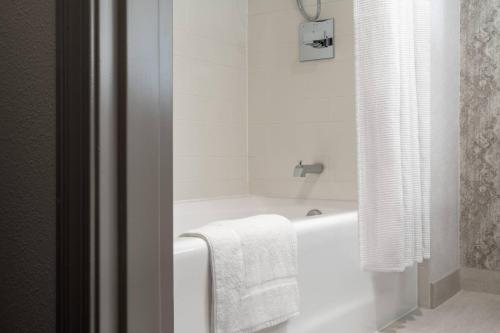 uma casa de banho com uma banheira e uma toalha em New Orleans Marriott Warehouse Arts District em Nova Orleans