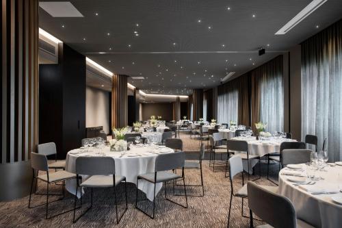 a conference room with white tables and chairs at Melbourne Marriott Hotel Docklands in Melbourne