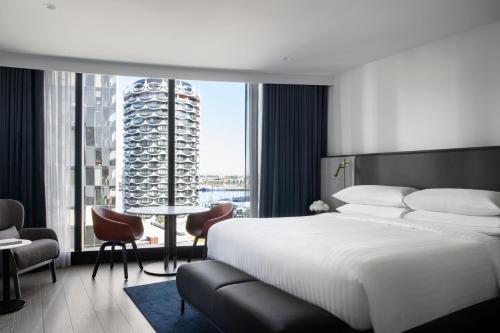 a bedroom with a large bed and a large window at Melbourne Marriott Hotel Docklands in Melbourne