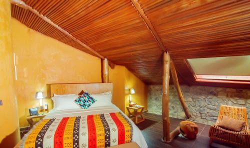 Trois Ore Residences & Green Earth Bistro في إيبادان: غرفة نوم بسرير وسقف خشبي