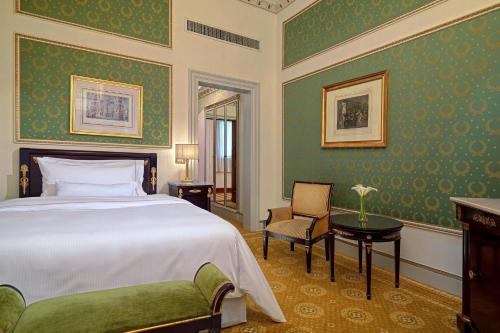 a bedroom with a bed and a chair and a table at The Westin Excelsior, Rome in Rome