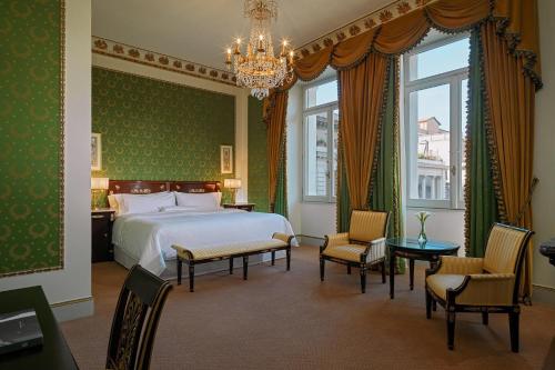 a bedroom with a bed and chairs and a chandelier at The Westin Excelsior, Rome in Rome
