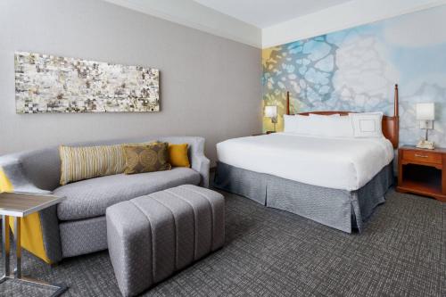 a hotel room with a bed and a couch at Courtyard Houston Downtown Convention Center in Houston