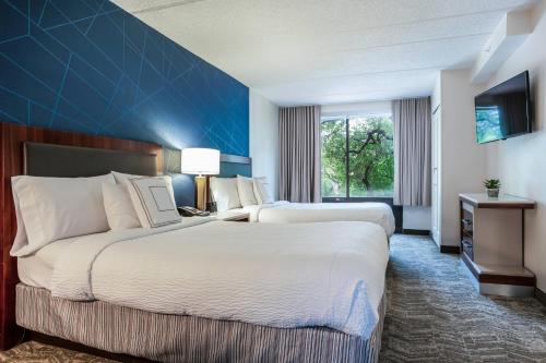 a hotel room with two beds and a blue wall at SpringHill Suites by Marriott Austin The Domain Area in Austin