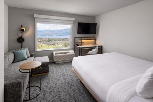 ウェストケロウナにあるTownePlace Suites by Marriott West Kelownaのベッドと窓が備わるホテルルーム
