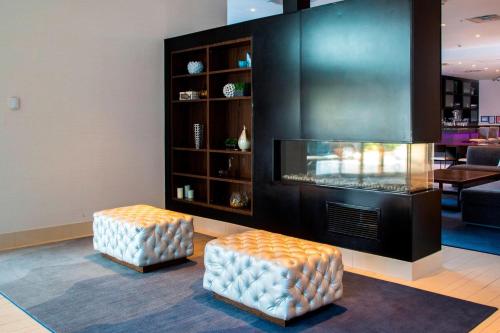 a living room with two stools and a fireplace at Residence Inn by Marriott The Bronx at Metro Center Atrium in Bronx
