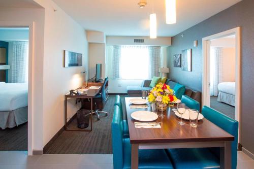 a room with a dining table and a living room at Residence Inn by Marriott The Bronx at Metro Center Atrium in Bronx