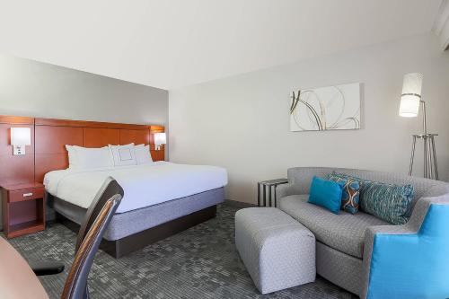 Habitación de hotel con cama y sofá en Courtyard by Marriott Monroe Airport en Monroe