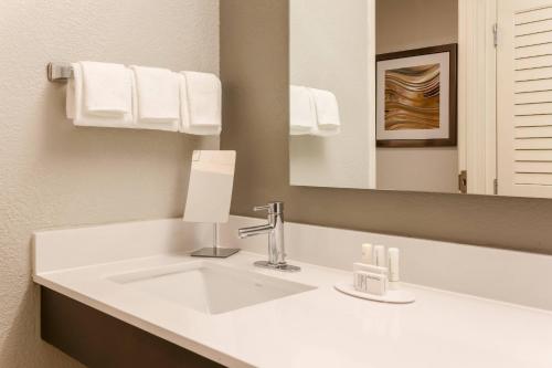een badkamer met een witte wastafel en een spiegel bij Courtyard by Marriott Monroe Airport in Monroe