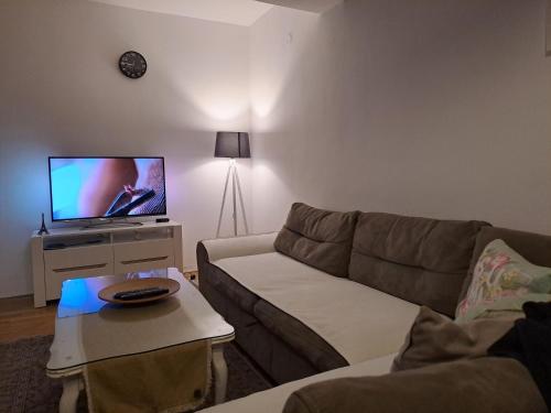 een woonkamer met een bank en een flatscreen-tv bij Prishtina Center Apartment in Pristina