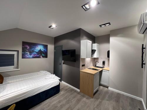 a bedroom with a bed and a small kitchen at Comfort Hostel Klaipeda in Klaipėda