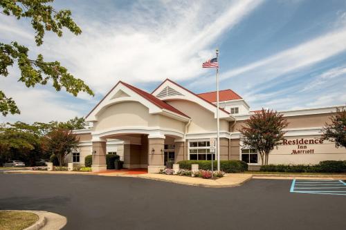 Um edifício de escritórios com uma bandeira americana à frente. em Residence Inn by Marriott Norfolk Airport em Norfolk