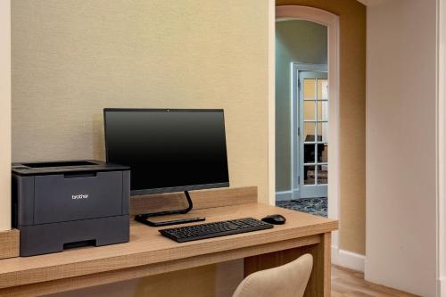 a desk with a computer monitor and a keyboard and mouse at Residence Inn by Marriott Norfolk Airport in Norfolk