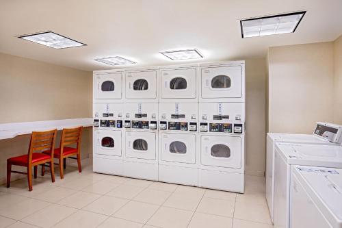 a laundry room with washing machines and two chairs at Residence Inn by Marriott Norfolk Airport in Norfolk