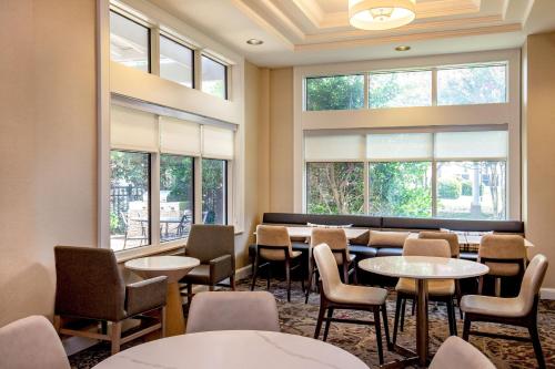 a waiting room with tables and chairs and windows at Residence Inn by Marriott Norfolk Airport in Norfolk