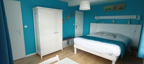 a blue bedroom with a bed and a white cabinet at Escales dans les dunes in Créances