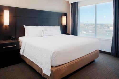 uma cama grande num quarto de hotel com uma janela grande em Residence Inn by Marriott Boulder Broomfield/Interlocken em Broomfield