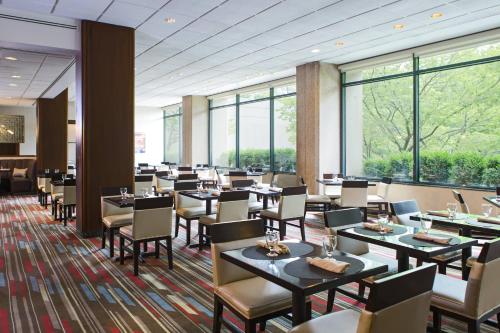 ハーンドンにあるワシントン ダレス マリオット スイーツのテーブルと椅子、大きな窓のあるレストラン