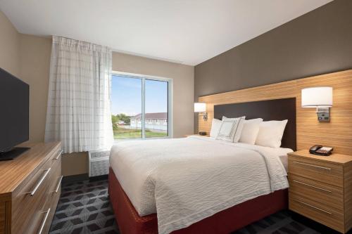 Habitación de hotel con cama grande y ventana en TownePlace Suites by Marriott Janesville, en Janesville