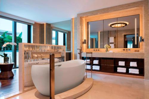a bathroom with a tub and a sink with a mirror at JW Marriott Hotel Macau in Macau