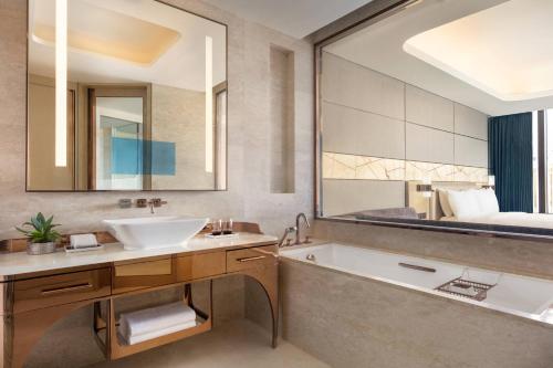 a bathroom with a sink and a tub and a bed at JW Marriott Hotel Macau in Macau