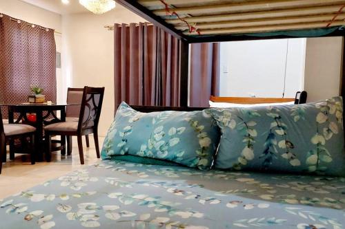 a bedroom with a bed with blue sheets and a table at YYY's Townhouse in Malolos