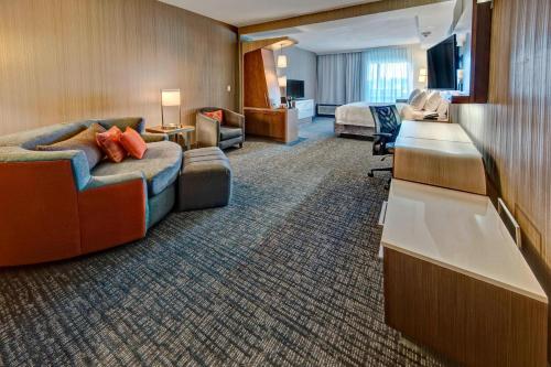 a hotel room with a bed and a desk at Courtyard by Marriott Westbury Long Island in Westbury