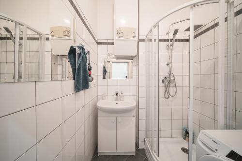 a white bathroom with a sink and a mirror at Josefov Riverside Apartment in Prague