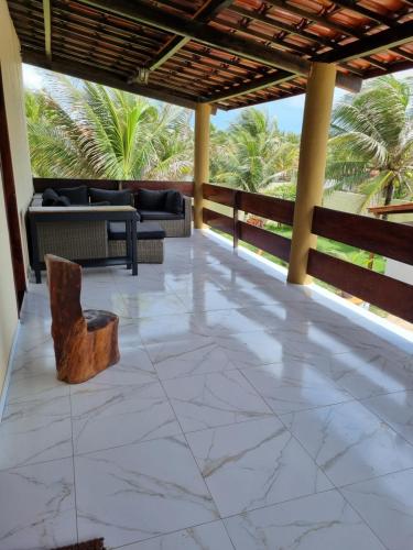 a patio with a couch and a chair on it at Casa Ferreira Cumbuco in Caucaia
