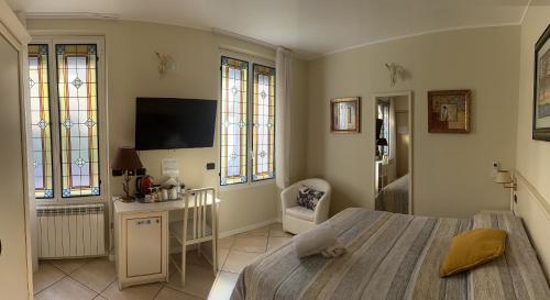 a bedroom with a bed and a desk and a tv at Camere Chicca in Sanremo